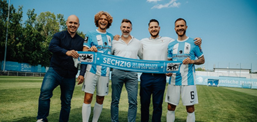 Verschiedene Vertreter des TSV 1860 halten gemeinsam einen Schal mit dem Schriftzug "Sechzig ist der geilste Club der Welt"