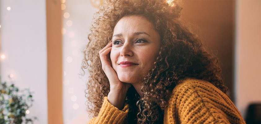 Junge Frau in Gedanken, hält Tasse in der Hand