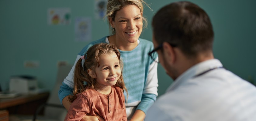 Eine Mutter sitzt mit ihrer kleinen Tochter beim Arzt