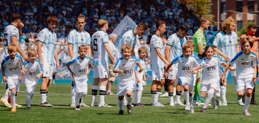 Mehrere Fußballspieler des TSV 1860 und Einlaufkinder
