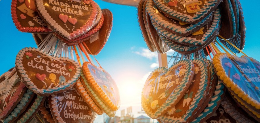 Fotografie von mehreren Wiesn-Lebkuchenherzen an einem Stand hängend.