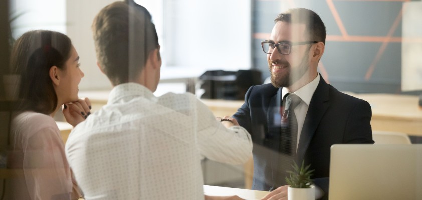 Ein Business-Mann führt ein Beratungsgespräch mit zwei Kunden. 