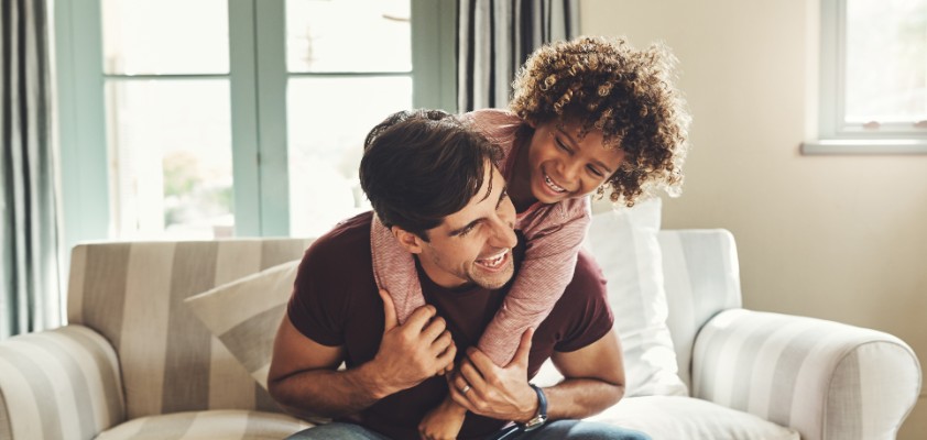 Vater und Kind tollen zuhause auf dem Sofa