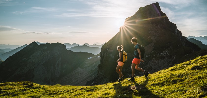 Zwei Frauen wandern an einem sonnigen Tag durch die Berge.