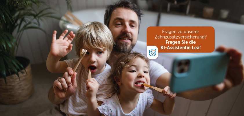 Ein Vater nimmt mit seiner Tochter und seinem Sohn ein Selfie auf, während sie beide am Zähne putzen sind. Im Bild der Schriftzug "Fragen zu unserer Zahnzusatzversicherung? Fragen Sie Lea!"