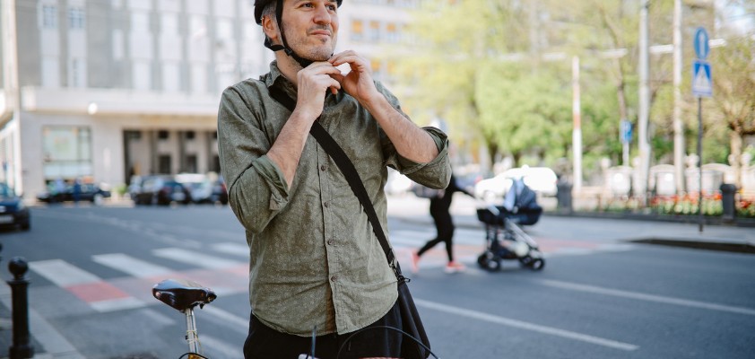 Ein Mann setzt seinen Fahrradhelm auf.