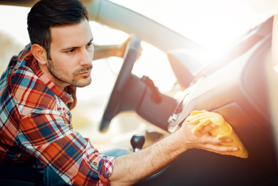 Ein Mann säubert die Beifahrerseite eines Autos Ein Mann säubert die Beifahrerseite eines Autos