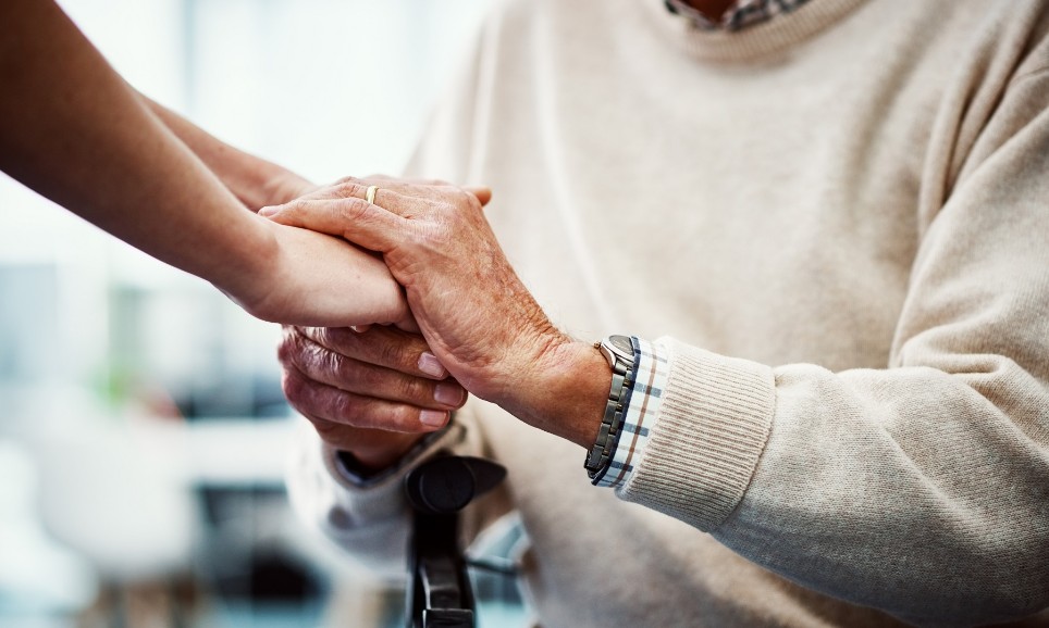 Beschnittene Aufnahme einer unkenntlichen Krankenschwester, die die Hand ihres älteren Patienten bequem hält Beschnittene Aufnahme einer unkenntlichen Krankenschwester, die die Hand ihres älteren Patienten bequem hält