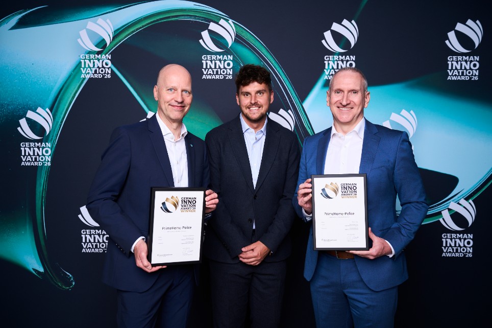 Das Bild zeigt drei männliche Mitarbeitende der Versicherungsgruppe die Bayerische, die den German Innovation Award entgegen nehmen. 