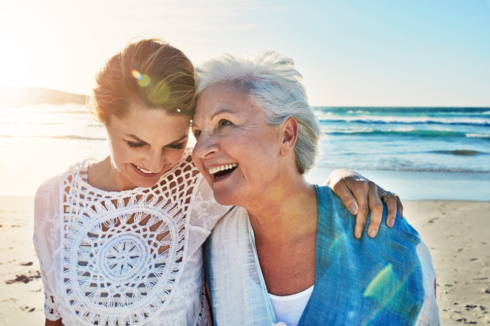 Mutter und erwachsene Tochter lachen am Strand Mutter und erwachsene Tochter lachen am Strand