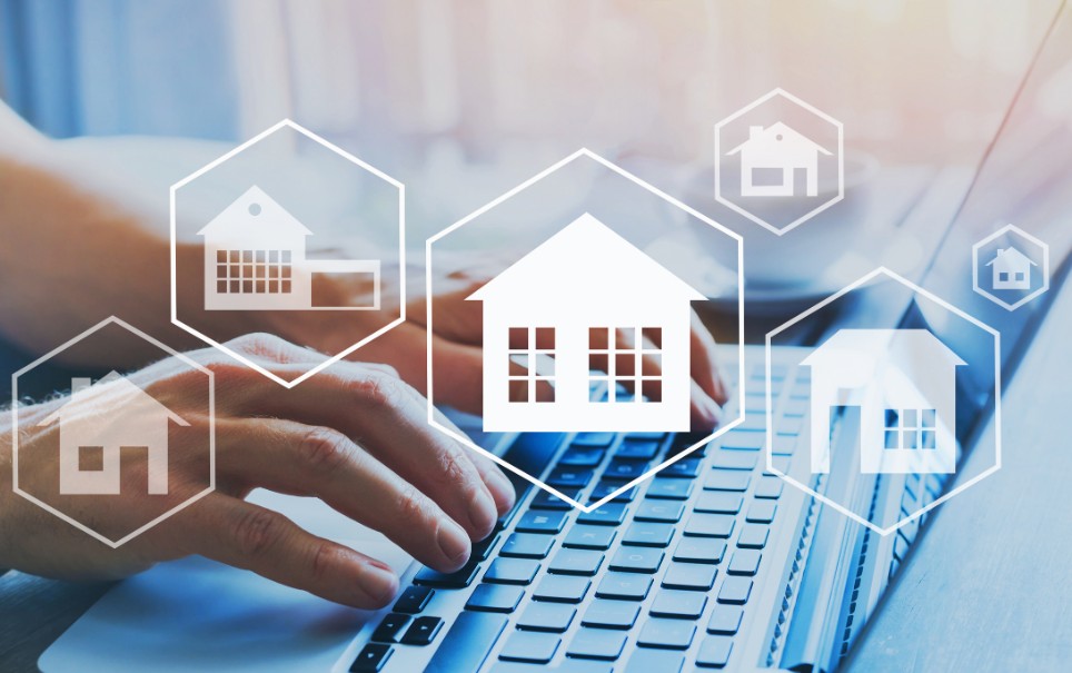 Im Hintergrund ein Laptop, im Vordergrund Symbole verschiedener Immobilien Im Hintergrund ein Laptop, im Vordergrund Symbole verschiedener Immobilien