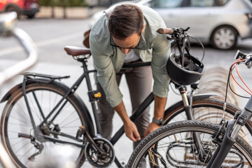Geschäftsmann, der sein Fahrrad auf einer Straße in der Stadt abschließt
