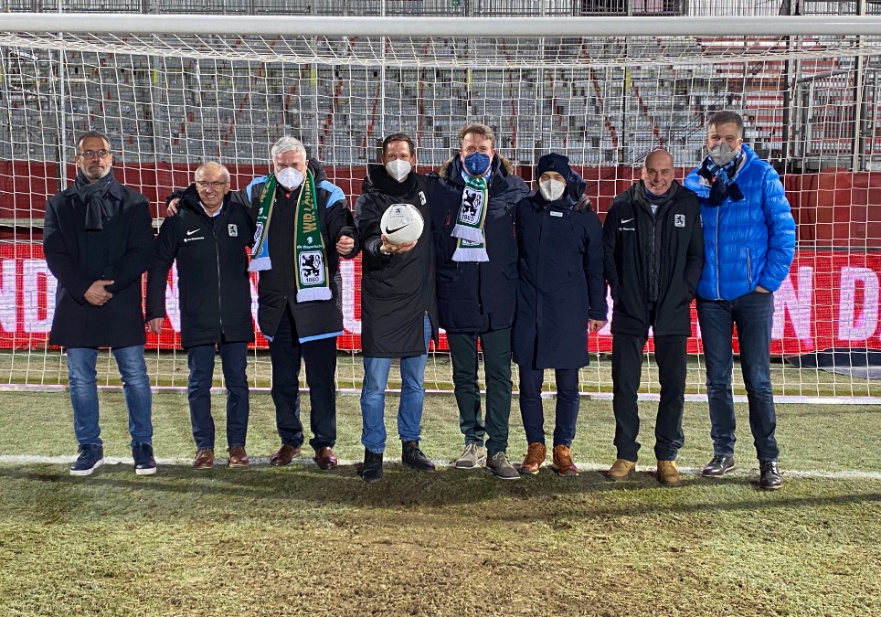 Die Vorstände der Bayerischen und die Führungsriege des TSV 1860 München nach dem Spiel gegen Würzburg am 20.12.2021. Marc-Nicolai Pfeifer hält den Fußball, auf den der Slogan "Gemeinsam in die Zukunft" geschrieben wurde und auf den alle drei Vorstände der Bayerischen unterschrieben haben.