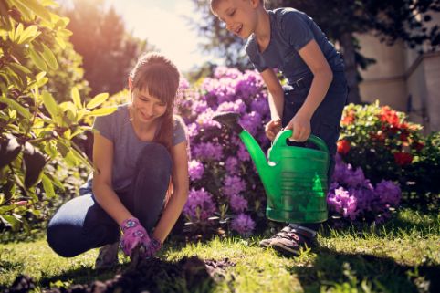 Zwei Kinder arbeiten gemeinsam im Garten